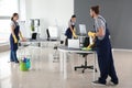 Team of janitors cleaning office