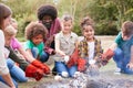 Team Leader With Group Of Children On Outdoor Activity Trip Toasting Marshmallows Over Camp Fire Royalty Free Stock Photo