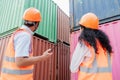 Team of logistics engineers, men and women in reflective jackets stand outside large commercial port. Containers in Export-Import