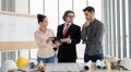 Team of male and female engineers and architects, working team, meeting, discussing construction and drawing construction plans, Royalty Free Stock Photo