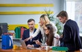 Team of mature women and men at meeting table discussing a business plan