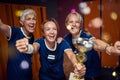 Team of mature women and young trainer in sportswaer uniform winning golden cup