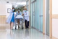 Team medical doctor pushing stretcher gurney bed corridor with female patient in hospital.