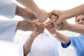Team of medical doctors putting hands together on light background. Unity concept Royalty Free Stock Photo