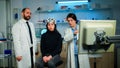 Team of medical researchers testing nervous system of woman patient Royalty Free Stock Photo