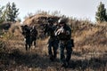 Team of military people outdoors, marines group in action, shooting with assault rifle Royalty Free Stock Photo