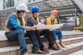 Team of multi ethnic engineer meeting and discussing with blueprint for a new project in construction site Royalty Free Stock Photo