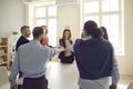 Team of diverse business people joining hands standing around table in corporate meeting Royalty Free Stock Photo