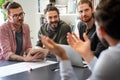 Team of multiethnic diverse young software developers talk, discuss an AI project. Business startup