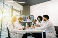 Team of multiracial five doctors sitting in light office, having video conference meeting with young, pretty African Royalty Free Stock Photo