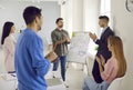 Team of people applauding their colleague for a business presentation in front of the whiteboard Royalty Free Stock Photo