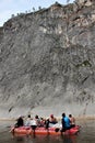 A team of people floating on the river in an inflatable catamaran among the beautiful cliffs. Selective focus.