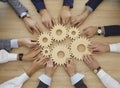 Team of people join cogwheels as metaphor for teamwork and effective business system