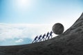 Team of people pushing stone uphill Royalty Free Stock Photo