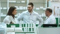 Team of pharmacist chemist woman and man standing in pharmacy drugstore and talking positive Royalty Free Stock Photo