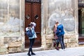 A team of photographers takes pictures of a romantic young man and a young woman hugging and kissing on the ancient street of the