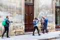 A team of photographers takes pictures of a romantic young man and a young woman hugging and kissing on the ancient street of the