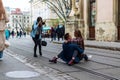 A team of photographers takes pictures of a romantic young man and a young woman hugging and kissing on the ancient street of the