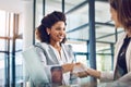 Team players who work together win together. two young businesswomen shaking hands in a modern office. Royalty Free Stock Photo