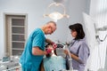 Team of professional dentists, man and woman, doing the treatment for young woman patient in their surgery dental clinic Royalty Free Stock Photo