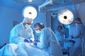 Team of doctors performing operation in surgery room