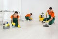 Team of professional janitors cleaning room after renovation