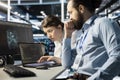 Team of programmers using notebook in server room, analyzing code Royalty Free Stock Photo