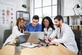 Qualified multi ethnic doctors cooperating during meeting Royalty Free Stock Photo