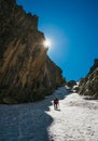 Team roping up woman with climbing axe dressed high altitude mountaineering clothes with backpack walking by snowy slope in the Royalty Free Stock Photo