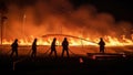 A team of firefighters working together to extinguish a large forest fire at night. Royalty Free Stock Photo