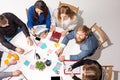 Team sitting behind desk, checking reports, talking. Top View Royalty Free Stock Photo