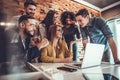 Team of six business people behind young businesswoman sitting and working on his laptop Royalty Free Stock Photo