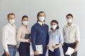 Team of startups in protective masks at work due to the epidemiological situation in the world.