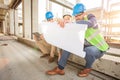 Group of young architects looking at floor plans during inspection of a construction site Royalty Free Stock Photo