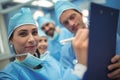 Team of surgeons having discussion over clipboard