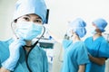 Team of surgeons in the operating room, female surgeon holding stethoscope and looking at camera