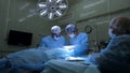 A team of surgeons perform facial nerve repair surgery. Group of professional surgeons and nurses in uniform performing