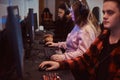 Team of teenage gamers plays in a multiplayer video game on pc in a gaming club.