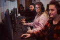 Team of teenage gamers plays in a multiplayer video game on pc in a gaming club.