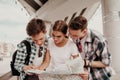 A Team Of Teenage Tourists Carefully Study The Map Together Walking On A Summer Day Around The City Royalty Free Stock Photo