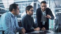 Team of Three Handsome Talented Young Engineers Use Computer to Discuss a Technological Project in