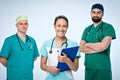 A team of three young doctors. The team included a doctor and a woman, two men doctors. They are dressed in scrubs. Royalty Free Stock Photo