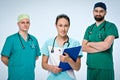 A team of three young doctors. The team included a doctor and a woman, two men doctors. They are dressed in scrubs. On the necks Royalty Free Stock Photo