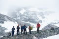 Team of travelers standing on rocky mountain road. Royalty Free Stock Photo