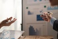 Team of two asian male business people working together discussing new financial graph data on office table with laptop Royalty Free Stock Photo