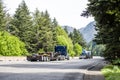 Team of two blue big rig semi trucks with step down semi trailers transporting transport equipment running at the convoy on the