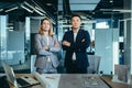 A team of two business people, an Asian man and a woman, look confidently at the camera, serious and focused with their hands Royalty Free Stock Photo