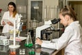 Team of two female laboratory technicians working in chemical or pharmaceutical laboratory