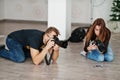 The team of two photographers shooting on studio at knees. Professional photographer on work. Master class