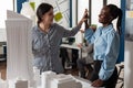 Team of two women architects high fiving standing in front of table with foam scale model Royalty Free Stock Photo